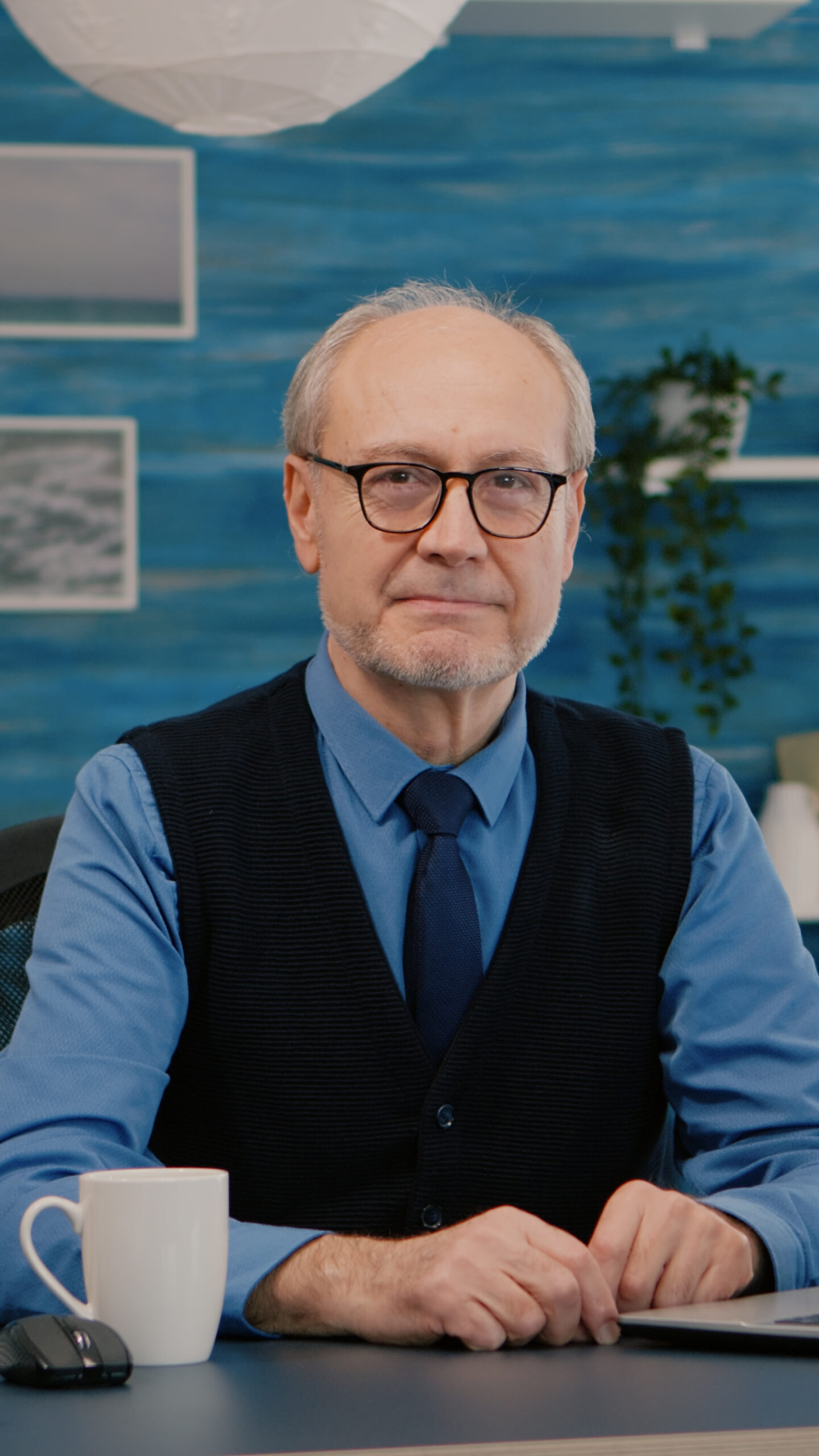 elderly-businessman-entrepreneur-sitting-workspace-looking-camera